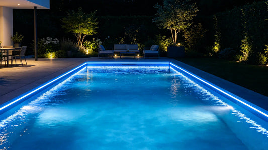 Blue LED strip lights installed along the edge of a modern swimming pool at night, creating a luxury outdoor lighting effect.