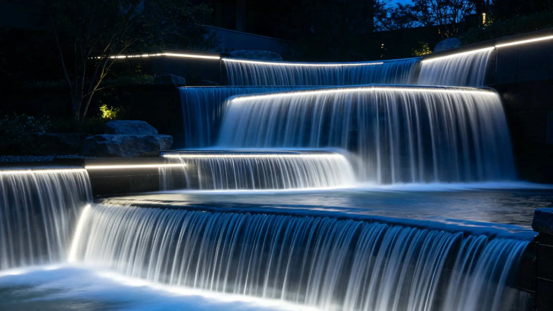 Waterfall illuminated with waterproof underwater LED strip lights in an outdoor landscape design